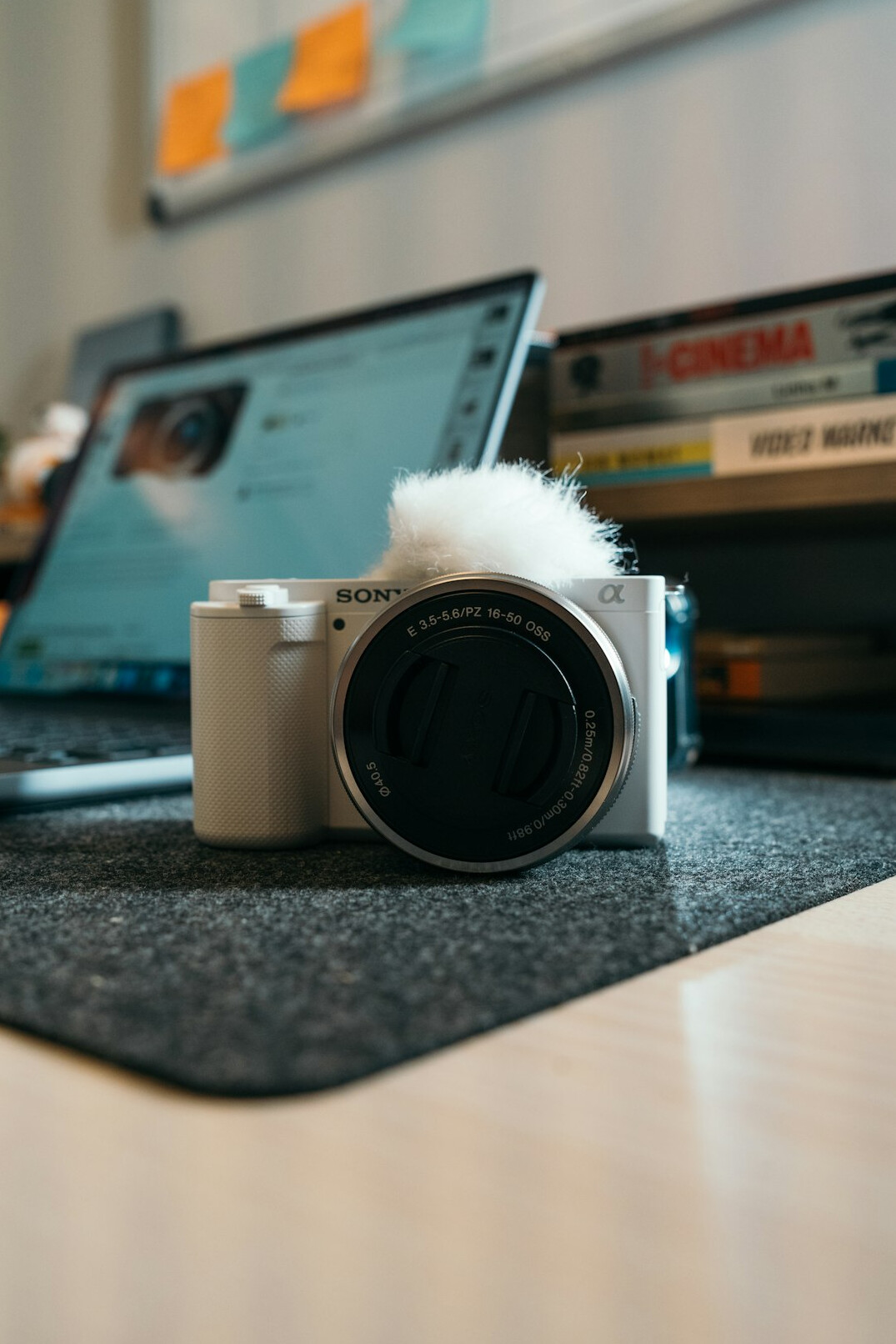 Camera, film negatives and laptop with photos on a wooden editing desk
